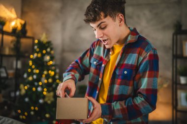 Şaşırdım genç adam evde noel hediyesini açtı.