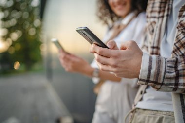 Yakın çekim yapan genç çift internet öndeki siyah duvarı keşfetmek için cep telefonu kullanıyor.