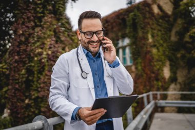 Doktor, panoyu tut ve terasta cep telefonu standında konuş.