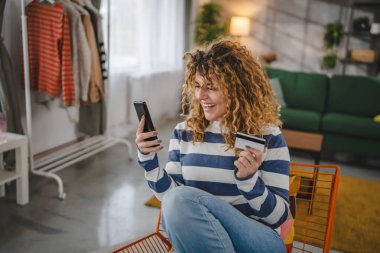 Yetişkin beyaz bir kadın mutlu bir gülümsemeyle banka kredi kartını online alışveriş bankacılığı konseptine sahip gerçek insanlar uzay e-ticaretini kopyalıyor ya da rezervasyon yaptırıyor.