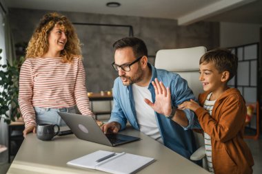 Baba, ailesi dikkatini dağıtırken evden çalışmaya çalışıyor.