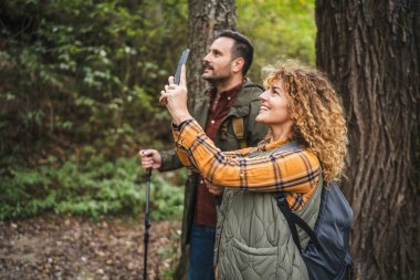 Yürüyüşçü çiftin yan görüntüsü. Karı koca, doğanın bir fotoğrafını çekin.