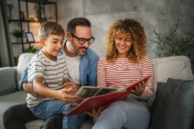 Anne, baba ve oğul eğlenirken aile albümlerini fotoğraflarla birlikte arayın.