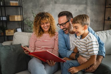 Anne, baba ve oğul eğlenirken aile albümlerini fotoğraflarla birlikte arayın.
