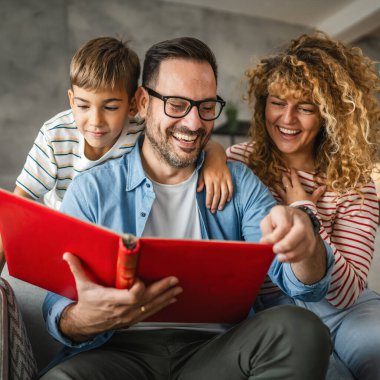 Anne, baba ve oğul eğlenirken aile albümlerini fotoğraflarla birlikte arayın.