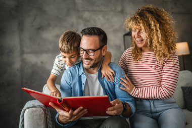 Anne, baba ve oğul eğlenirken aile albümlerini fotoğraflarla birlikte arayın.