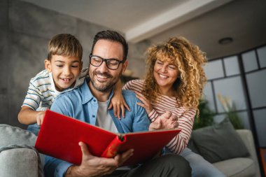 Anne, baba ve oğul eğlenirken aile albümlerini fotoğraflarla birlikte arayın.