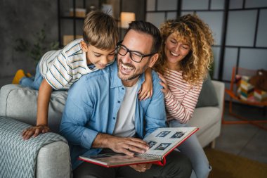 Anne, baba ve oğul eğlenirken aile albümlerini fotoğraflarla birlikte arayın.