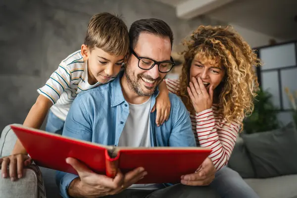 Anne, baba ve oğul eğlenirken aile albümlerini fotoğraflarla birlikte arayın.