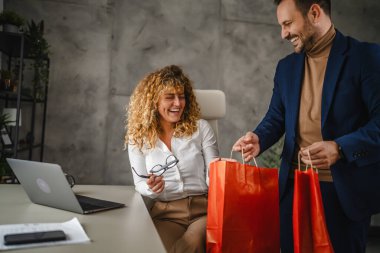 Erkek arkadaş, alışveriş torbalarıyla sürpriz yapıyor. Ofisteki bayan meslektaşı.