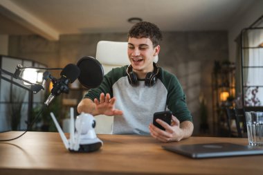 Genç adam teknolojisi blogcusu video blogu ya da video blogu kaydediyor ya da cep telefonunun ev kameralarına nasıl bağlanacağını kaydediyor
