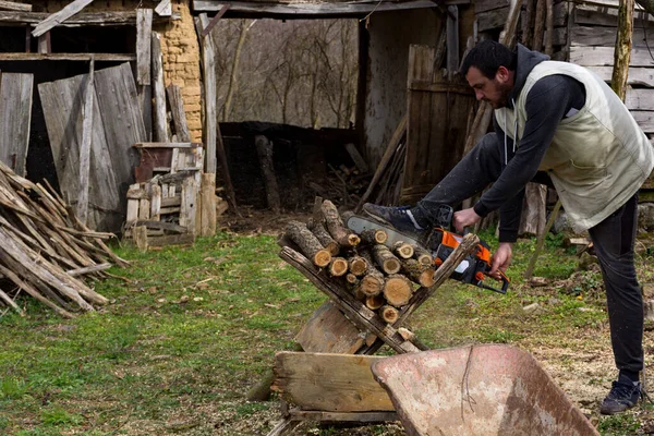 Man Cutting Firewood Chainsaw Yard Rural Area Cold Early Spring — Stock Photo, Image