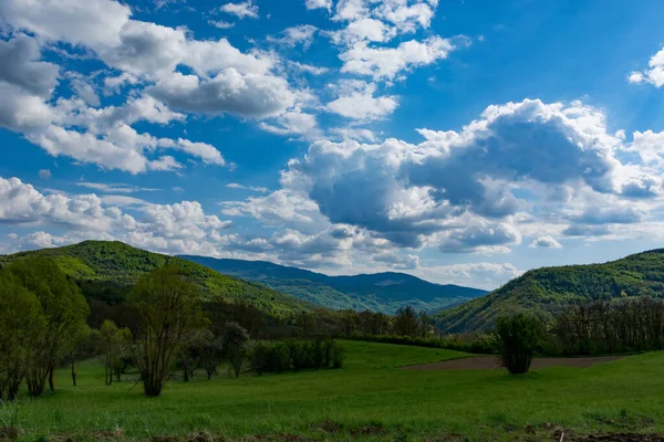 Krajobraz Natury Słonecznymi Wzgórzami Łąkami Któremu Towarzyszą Białe Puszyste Chmury — Zdjęcie stockowe