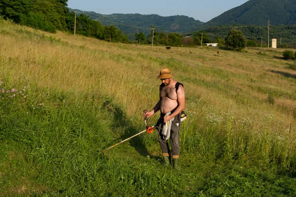 Man Straw Hat Trims Tall Grass Using Trimmer Large Rural — Stock Photo, Image