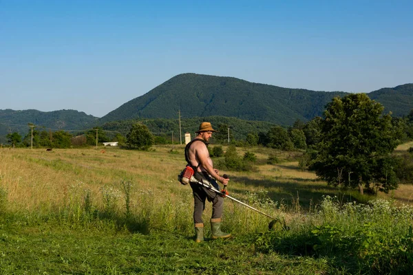 Farmer Trims Tall Grass Sunny Hot Meadow Using Trimmer Backdrop — Stock Photo, Image