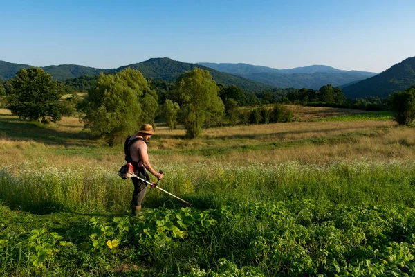 Sunset Farmer Trims Tall Grass His Vegetable Garden Using Trimmer — Stock Photo, Image