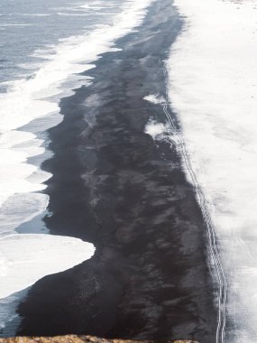 Ingjaldshlskirkja Kilisesi İzlanda 'da dramatik fırtına bulutlarının altında karlı bir tepede. Snfellsnes Yarımadası 'ndaki kırmızı çatılı şapel ve karanlık kış gökyüzü arasında çarpıcı bir tezat