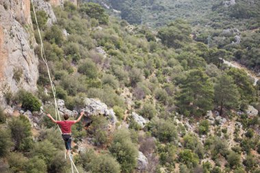 Bir ip cambazı uçurumun üzerinde bir ip üzerinde dengede durur..