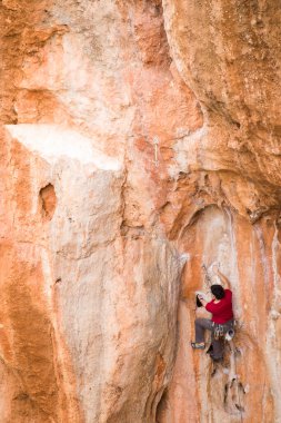Bir dağcı zor bir yola tırmanır..