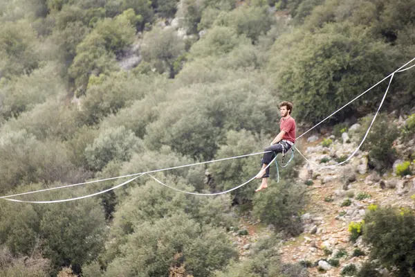 Bir adam uçurumun üzerinde ip üzerinde yürür..