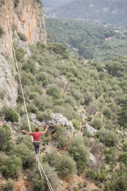 Bir adam uçurumun üzerinde ip üzerinde yürür..