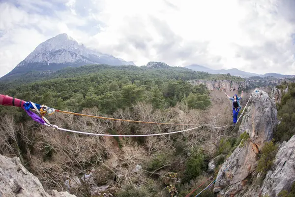 stock image A tightrope walker walks along a rope stretched over a canyon.