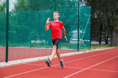 Bir atlet stadyumda özel koşu egzersizleri yapıyor..