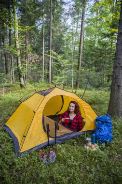 Genç bir kız bir açıklıktaki çadırda dinleniyor..