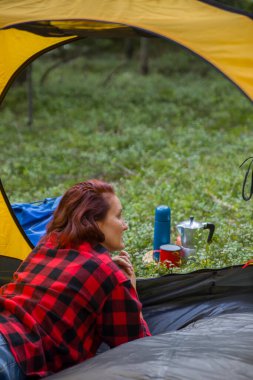 Genç bir kız bir açıklıktaki çadırda dinleniyor..
