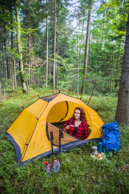 Ormanın ortasındaki bir açıklıkta kamp yapmak. Genç bir kız çadırda dinleniyor..
