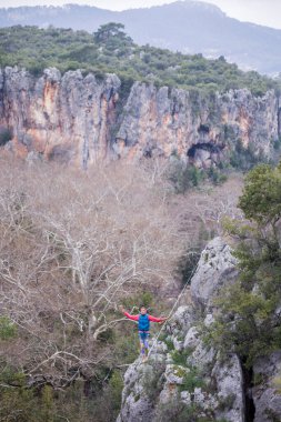 Bir ip cambazı, kanyonun üzerinde gerilmiş bir kablo boyunca yürür..