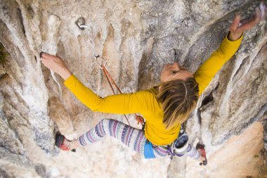 Bir kaya tırmanıcısı zor bir yoldan zirveye tırmanır..