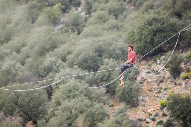 Bir ip cambazı, kanyonun üzerinde gerilmiş bir kablo boyunca yürür..