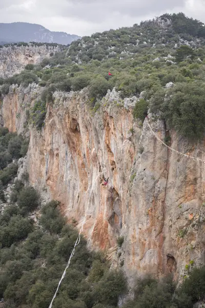 stock image A tightrope walker walks along a cable stretched over a canyon.