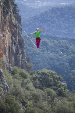 Bir ip cambazı, kanyonun üzerinde gerilmiş bir kablo boyunca yürür..