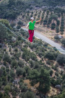 Bir ip cambazı, kanyonun üzerinde gerilmiş bir kablo boyunca yürür..