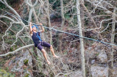 Bir ip cambazı, kanyonun üzerinde gerilmiş bir kablo boyunca yürür..