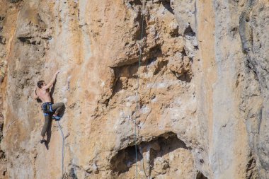 Bir kaya tırmanıcısı zor bir yoldan zirveye tırmanır..