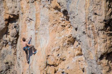 Bir kaya tırmanıcısı zor bir yoldan zirveye tırmanır..
