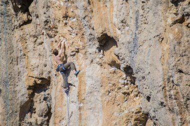 Bir kaya tırmanıcısı zor bir yoldan zirveye tırmanır..