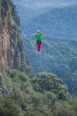 Bir ip cambazı, kanyonun üzerinde gerilmiş bir kablo boyunca yürür..