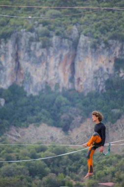 Bir ip cambazı, kanyonun üzerinde gerilmiş bir kablo boyunca yürür..