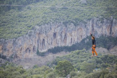 Bir ip cambazı, kanyonun üzerinde gerilmiş bir kablo boyunca yürür..