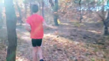 Bir atlet sonbahar ormanlarında koşar..