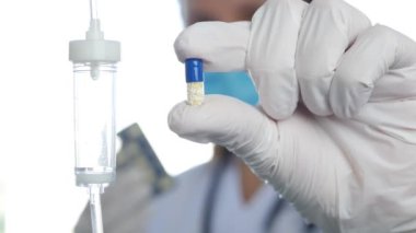 Blurred Image with Doctor Wearing Protective Mask and Surgery Gloves in a Hospital Emergency Room Checking Medical Pills