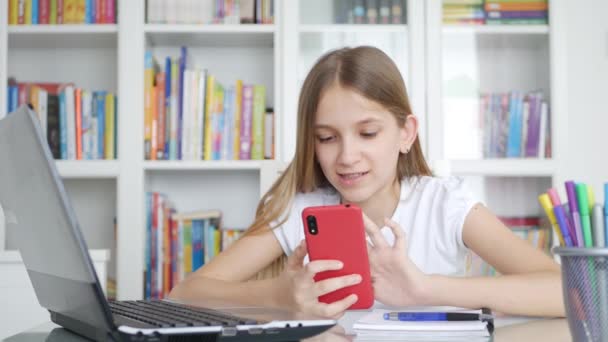 ビデオ会議 子供の学習 図書館での執筆 女子高生チャット オンライン教育でのスマートフォンの勉強を使用して子供 — ストック動画