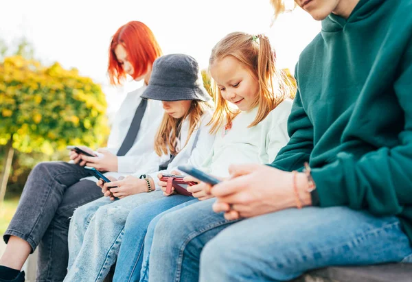 Tinédzser Fiú Egy Lánytestvér Gyerekek Ülnek Nézegetik Okostelefonjukat Őszi Parkban — Stock Fotó