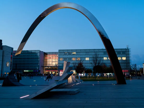 stock image Krakow, Poland - November 2, 2022: Square Plac Nowaka-Jezioraskiego with Monument Ryszarda Kuklinskiego Arch with Galeria Krakowska Shopping Mall on background, Krakow, Poland.