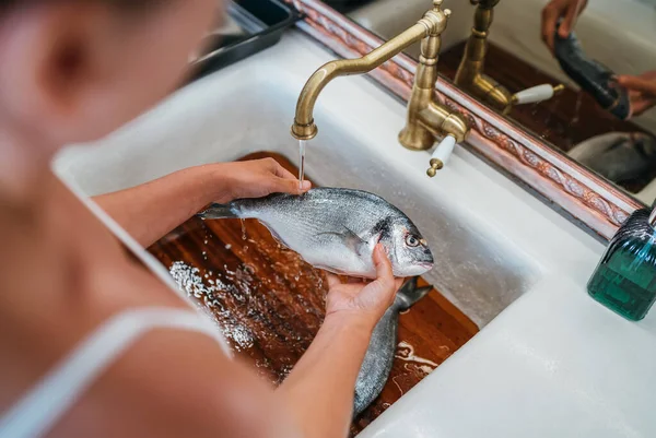 Молода Жінка Очищає Свіжу Орату Або Рибу Дораду Після Випаровування — стокове фото