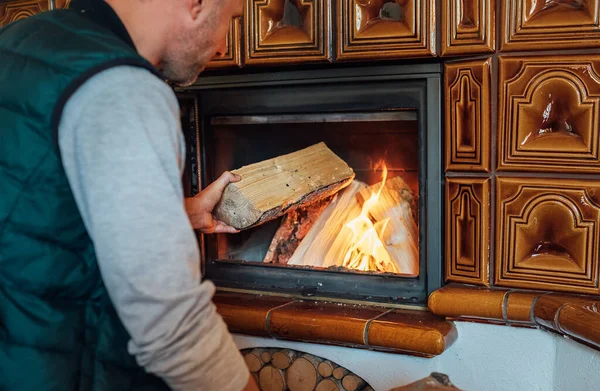 家のMantelの火に木の丸太を置く人 — ストック写真